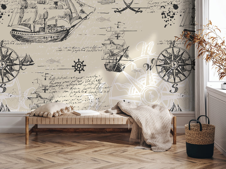 a room with a large wall mural depicting various nautical elements, including ships, a compass, and other maritime symbols. In the foreground, there is a bench with a blanket draped over it, and a woven basket is placed nearby. The overall setting appears to be a cozy and inviting space, with the mural serving as a focal point and adding a touch of nautical charm to the room.