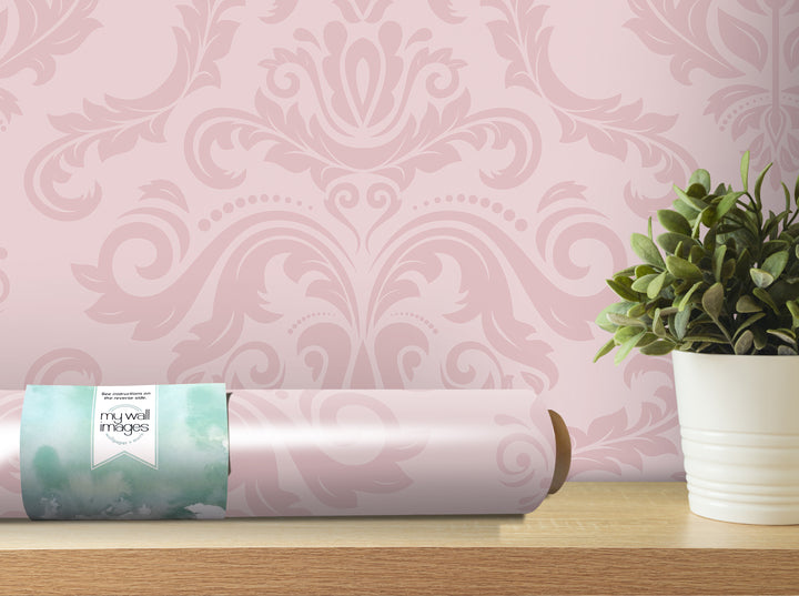 a pink wallpaper with a floral pattern, a roll of wallpaper paper, and a potted plant on a wooden shelf.