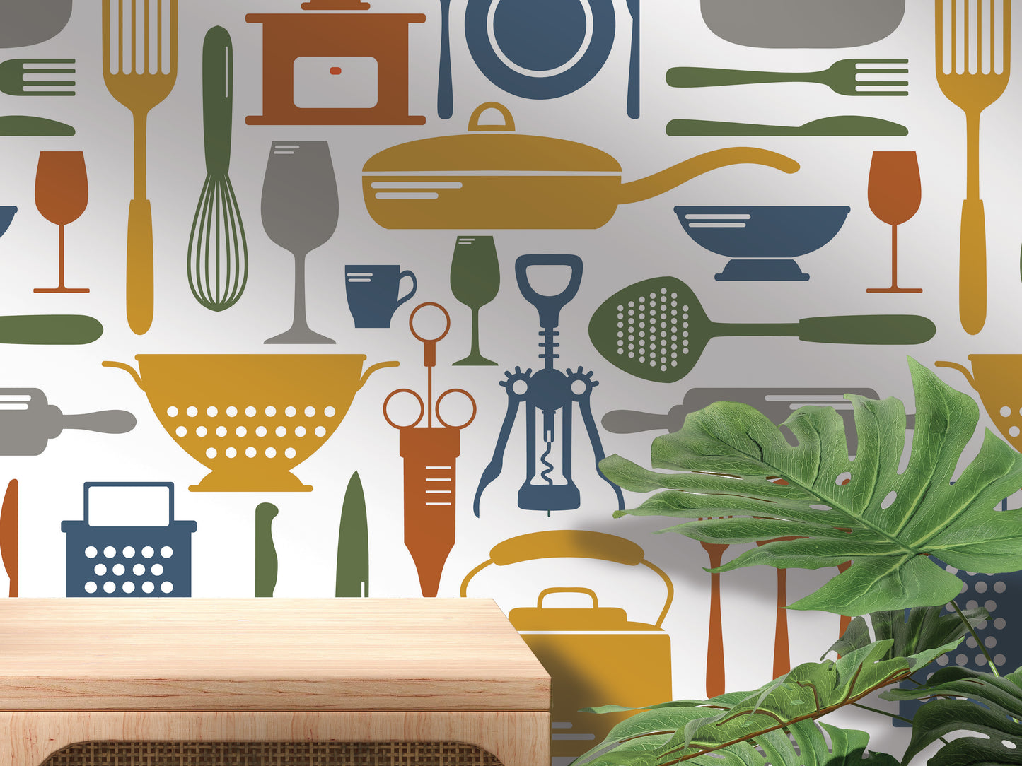 a wall with a repeating pattern of various kitchen utensils and appliances, including a variety of spoons, forks, knives, bowls, and other cooking-related items. In the foreground, there is a wooden table or shelf, and a plant is visible in the background.