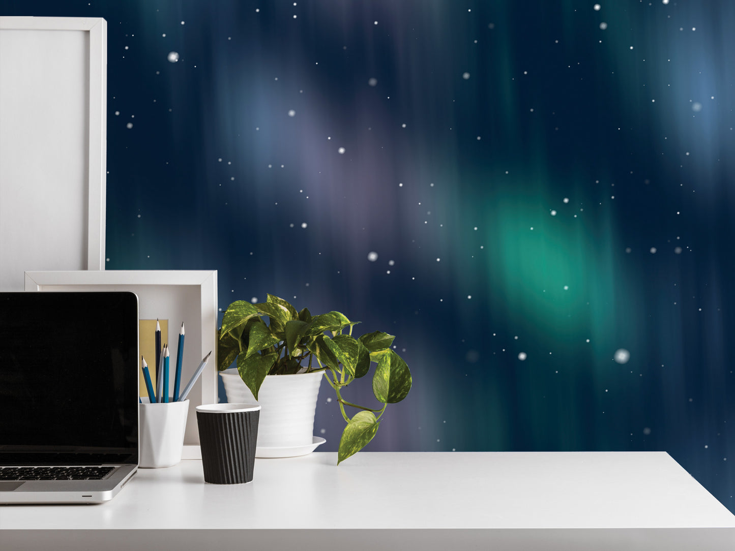 a white desk with a laptop, a plant, and a cup, set against a backdrop of a starry night sky.