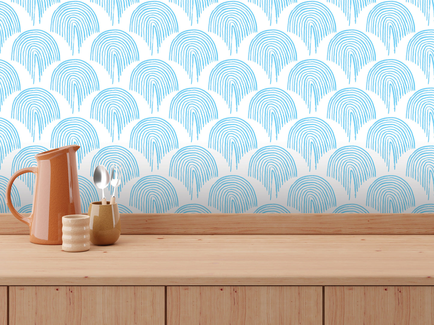 a wooden countertop with various kitchen utensils and a pitcher, set against a patterned blue and white wall.