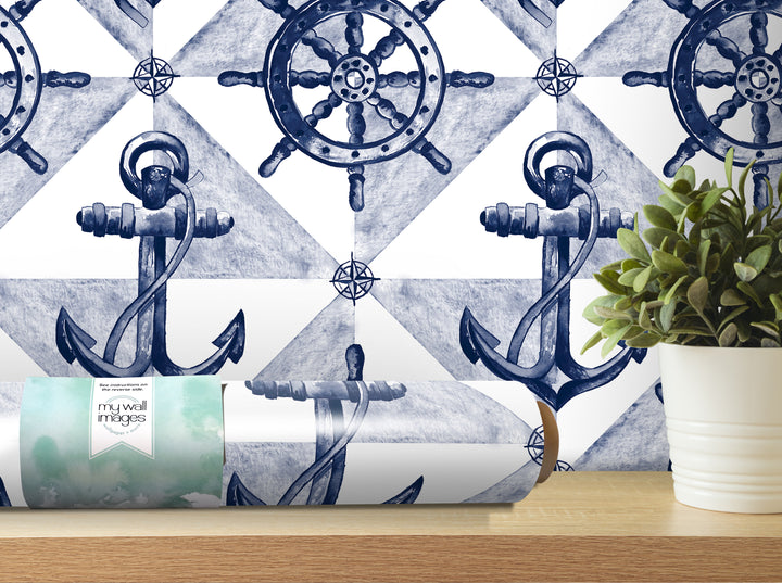 a wallpapered wall with a repeating pattern of anchors and a ship's wheel, along with a potted plant and a roll of wallpaper on a shelf.