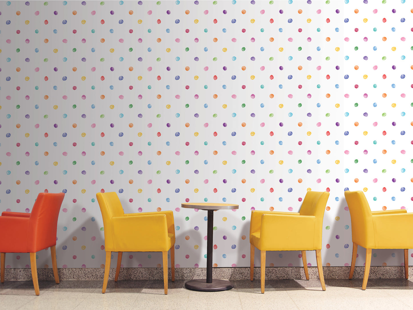 a vibrant and playful setting with a wall adorned with colorful polka dots. In the foreground, there are four yellow chairs arranged around a small round table, creating a cozy seating area. The chairs are positioned in a way that they face the wall, inviting conversation and interaction. The overall scene exudes a cheerful and lively atmosphere.