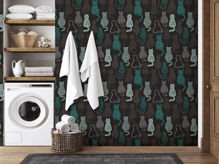 a bathroom with a black and teal cat wallpaper, a white washing machine, and a basket of towels.