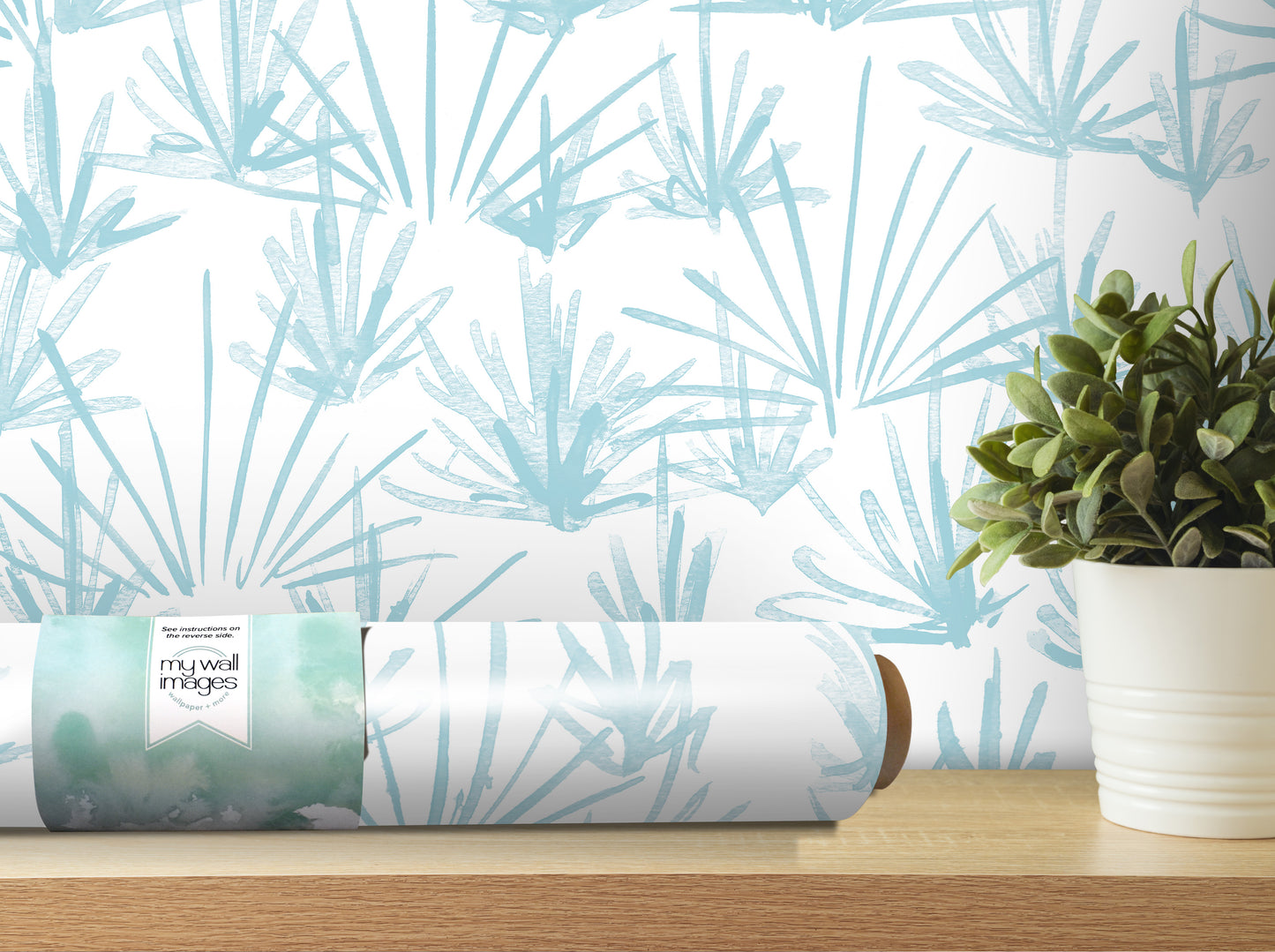 a roll of wallpaper with a blue and white pattern, placed on a wooden shelf next to a potted plant.