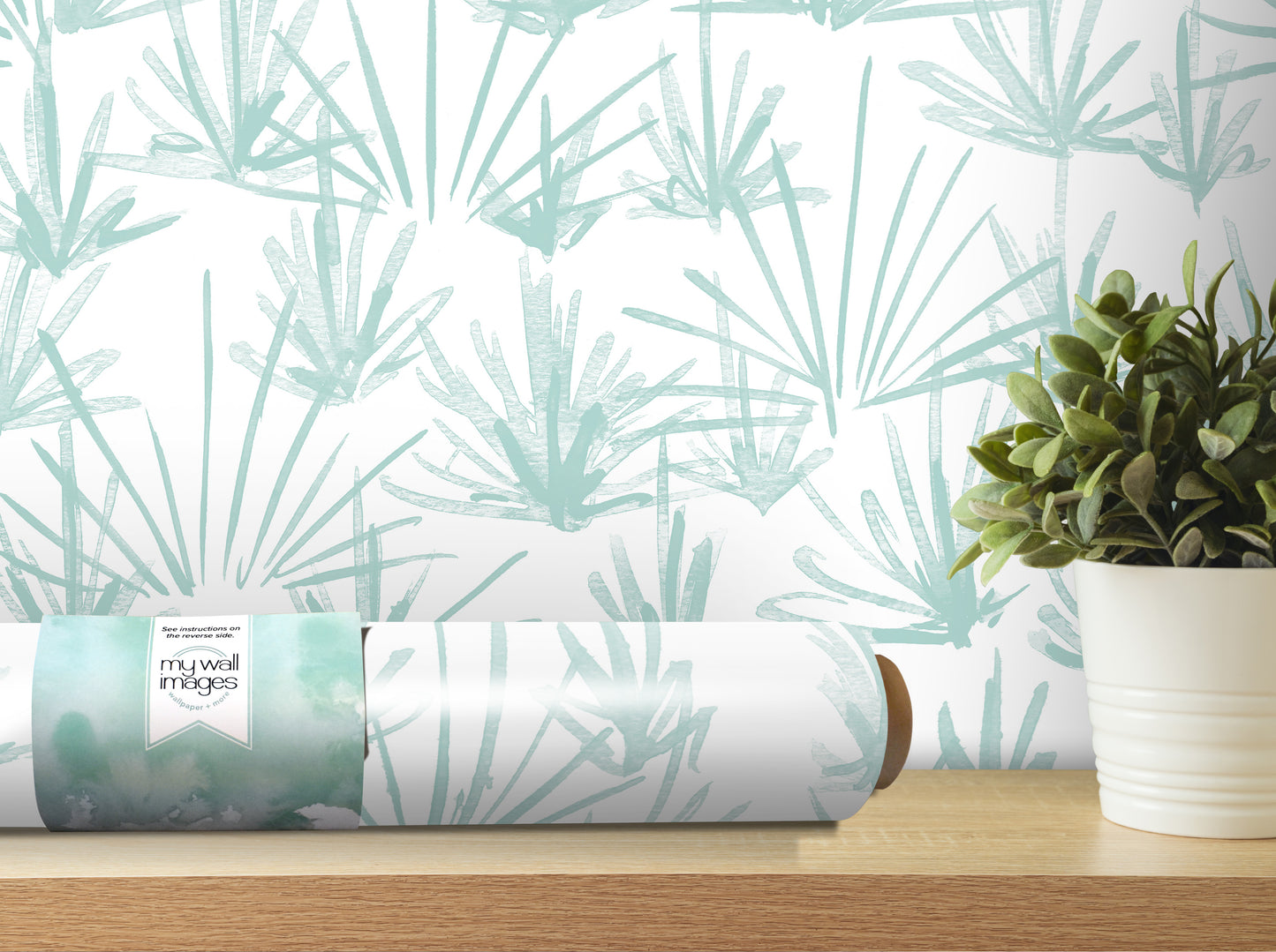 a roll of wallpaper with a pattern of green leaves, placed on a wooden shelf next to a potted plant.