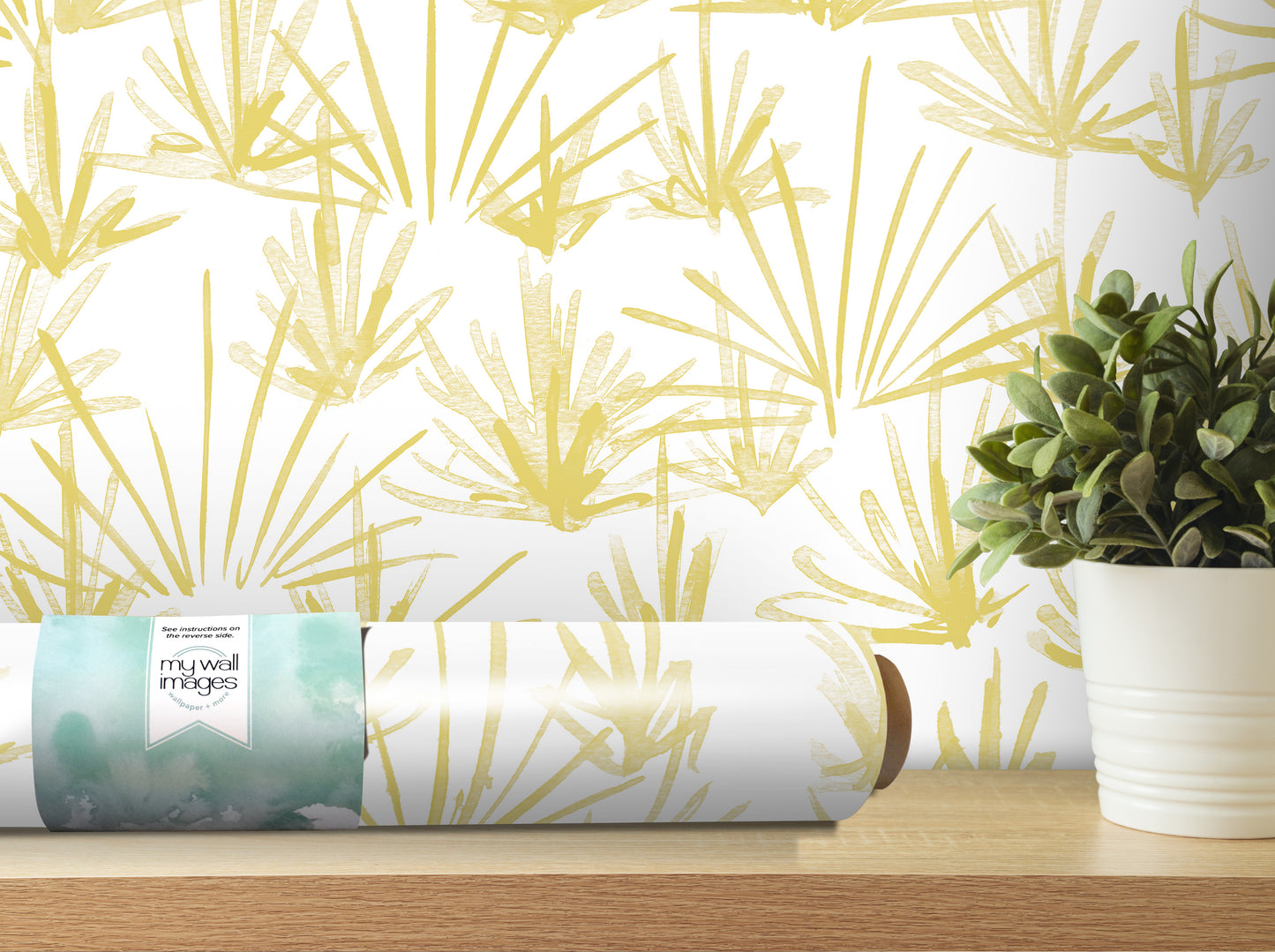 a wallpapered wall with a yellow and green leaf pattern, a potted plant, and a roll of wallpaper on a shelf.