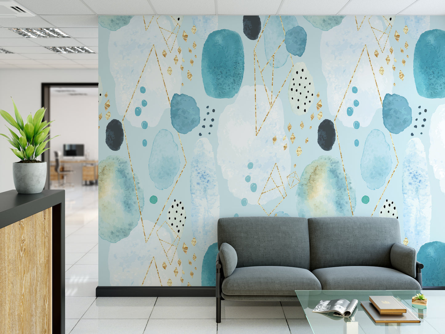 a modern office space with a gray sofa and a glass coffee table in the foreground. The wall behind the sofa is covered in a vibrant abstract pattern in shades of blue, green, and gold, creating a visually striking backdrop for the room.