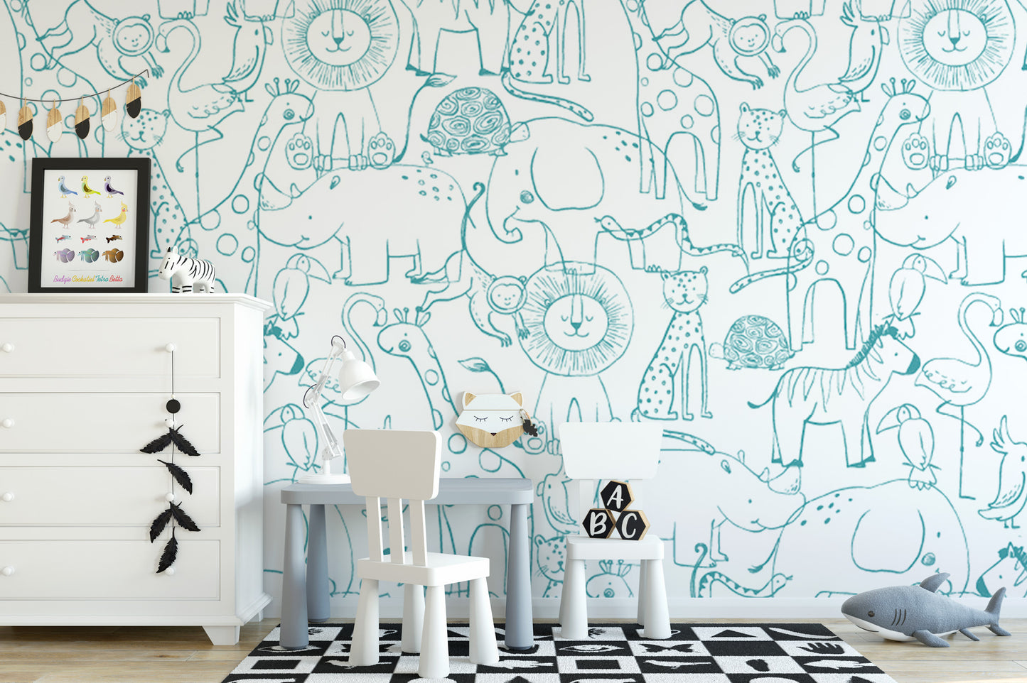 a child's bedroom with a white dresser, a small table with a chair, and a wallpapered wall with various animal illustrations.