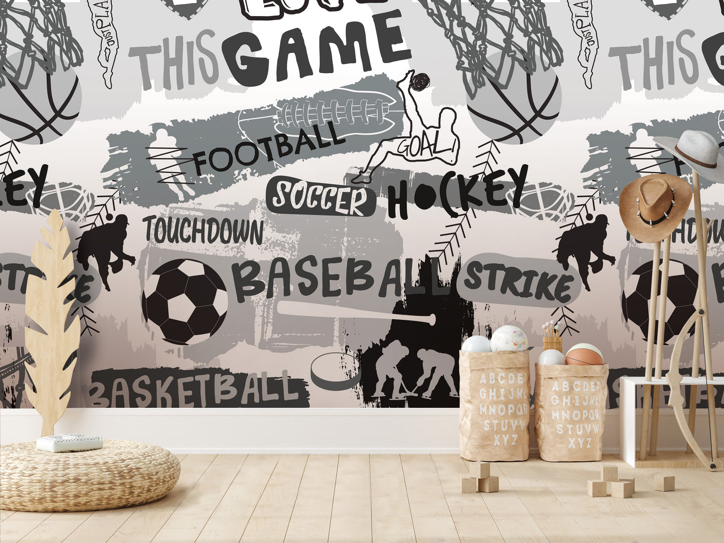 a wall with a collage of various sports-related images, including basketballs, soccer balls, and baseballs, along with the words "FOOTBALL", "SOCCER", "HOCKEY", "TOUCHDOWN", "BASEBALL", and "BASKETBALL". The wall also includes some text and illustrations related to sports, such as a person playing soccer and a person playing basketball. The overall scene appears to be a sports-themed room or space.