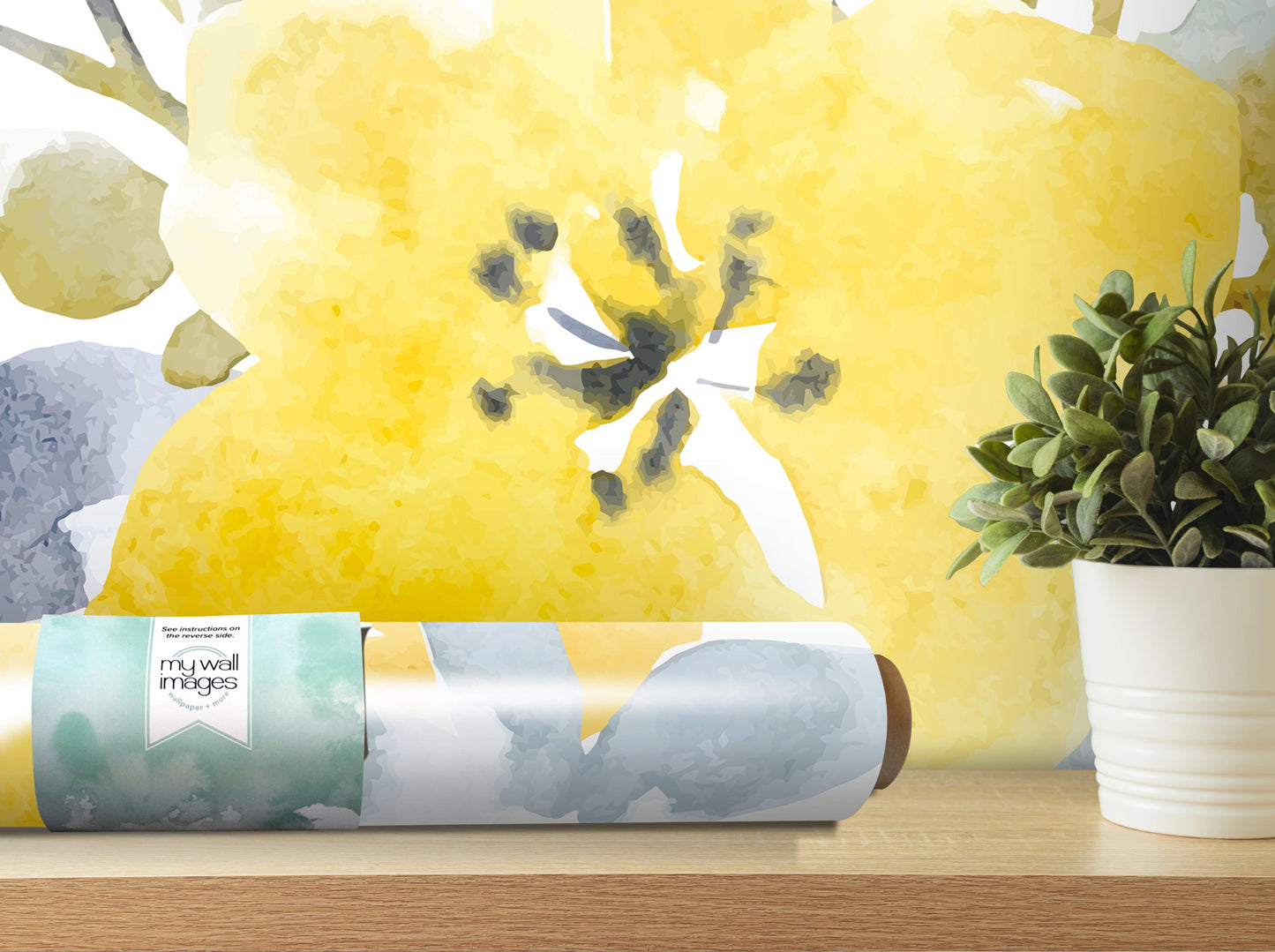 a large yellow flower on a wall, with a potted plant to the right and a roll of wallpaper or decal on a shelf in the foreground.
