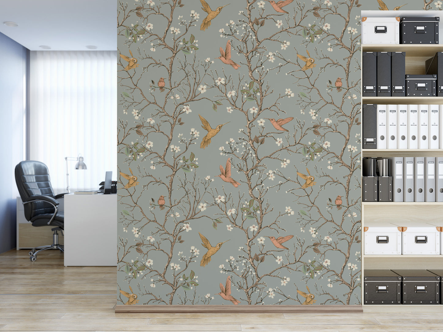 a modern office space with a large wallpapered wall adorned with a floral pattern of birds and branches. The office is furnished with a desk, chair, and shelves filled with various items, including books and folders.