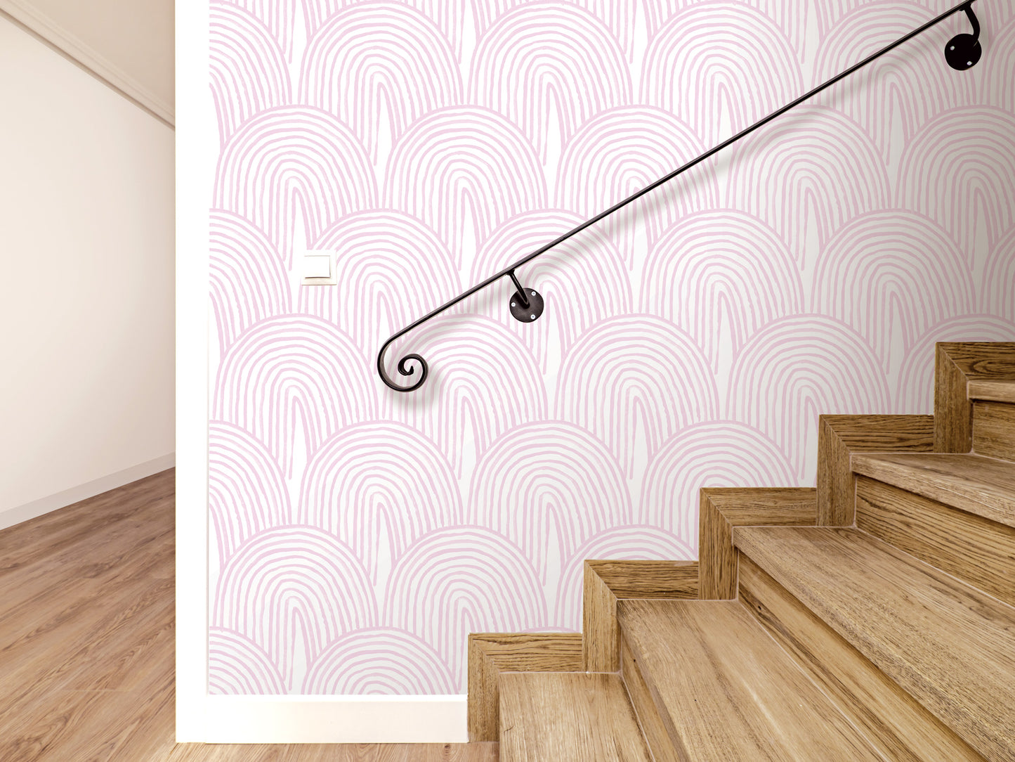 a staircase with wooden steps and a black metal handrail. The walls have a pink and white patterned wallpaper.