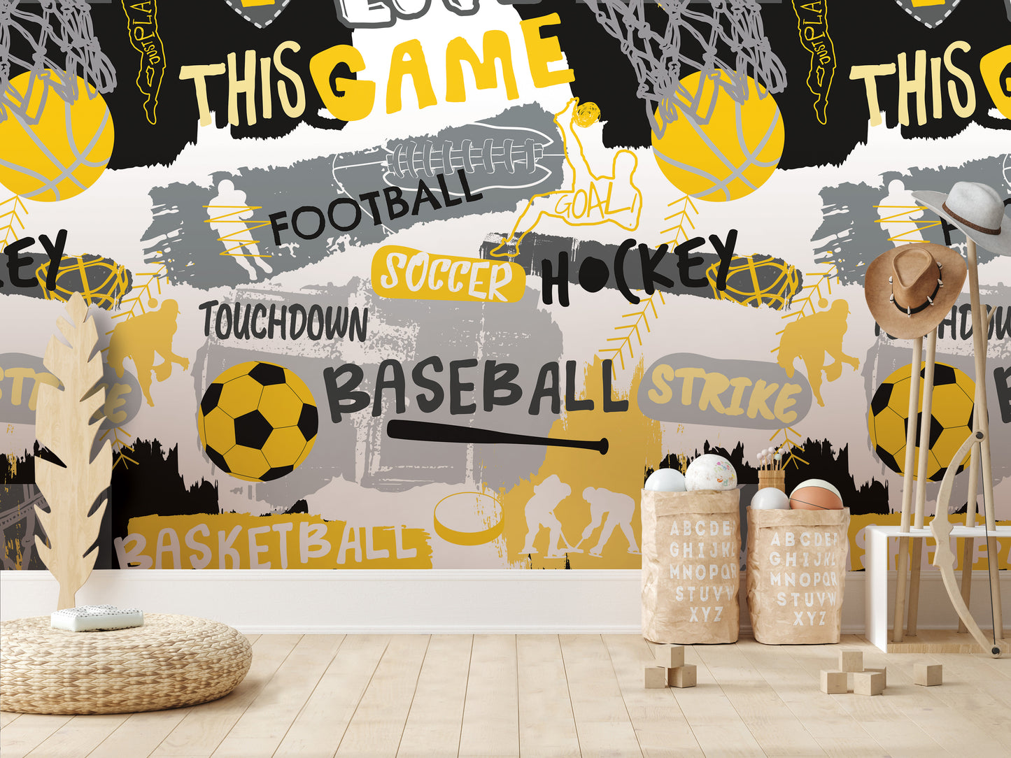 a wall with a collage of various sports-related words and images, including football, soccer, hockey, basketball, and baseball. The wall is decorated with a mix of black, yellow, and gray colors, creating a vibrant and energetic atmosphere. In the foreground, there are some baskets and a chair, suggesting a casual, relaxed setting.