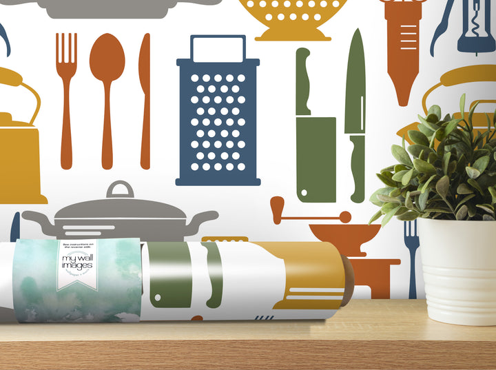 a wall with a variety of kitchen utensils and appliances, including a grater, knives, spoons, and a potted plant, all arranged in a visually appealing manner.
