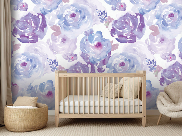 a nursery room with a wooden crib, a beige chair, and a woven basket. The walls are decorated with a floral wallpaper in shades of purple and blue.