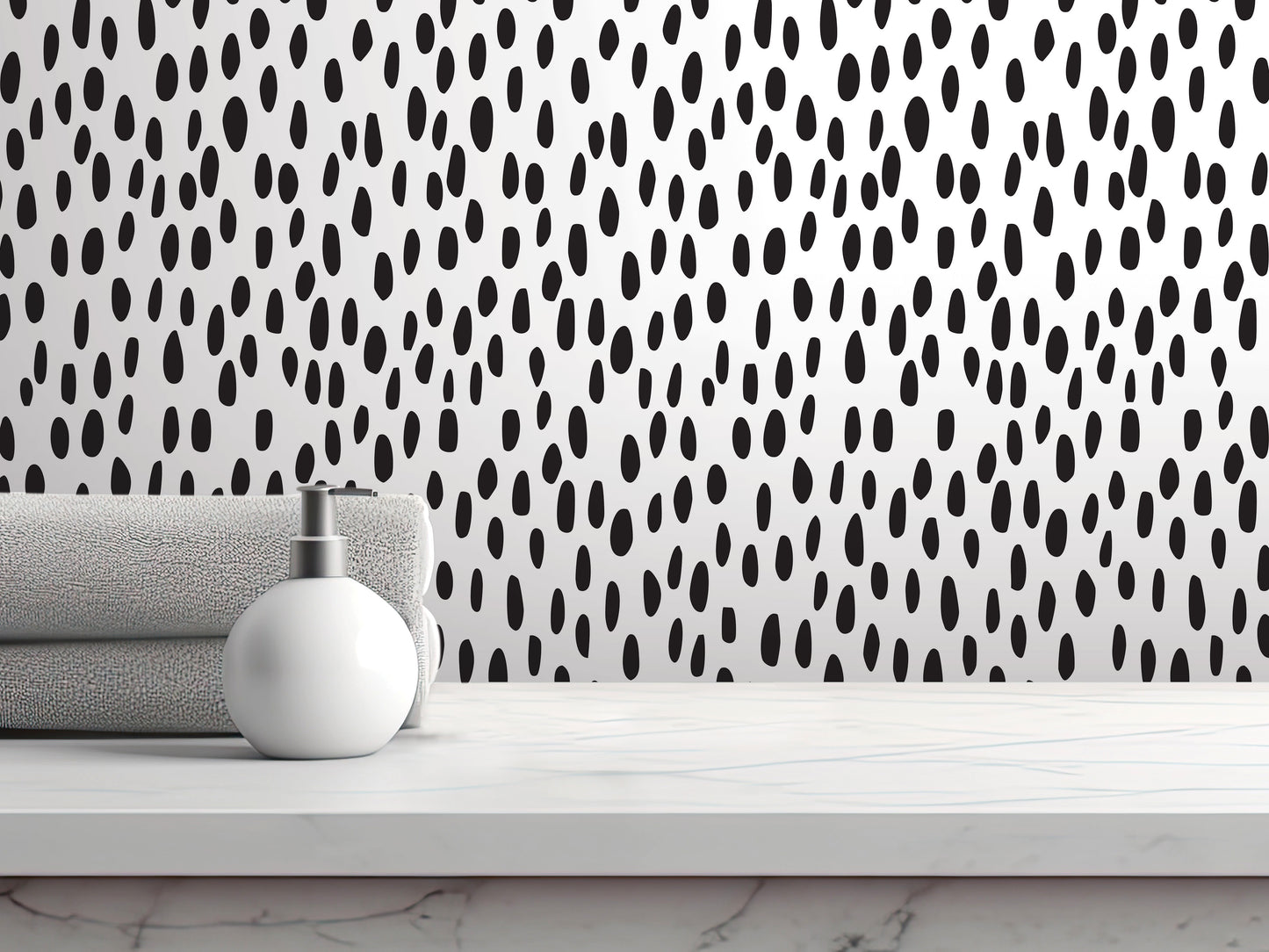 a white countertop with a white soap dispenser and a folded towel, set against a black and white polka dot patterned wall.