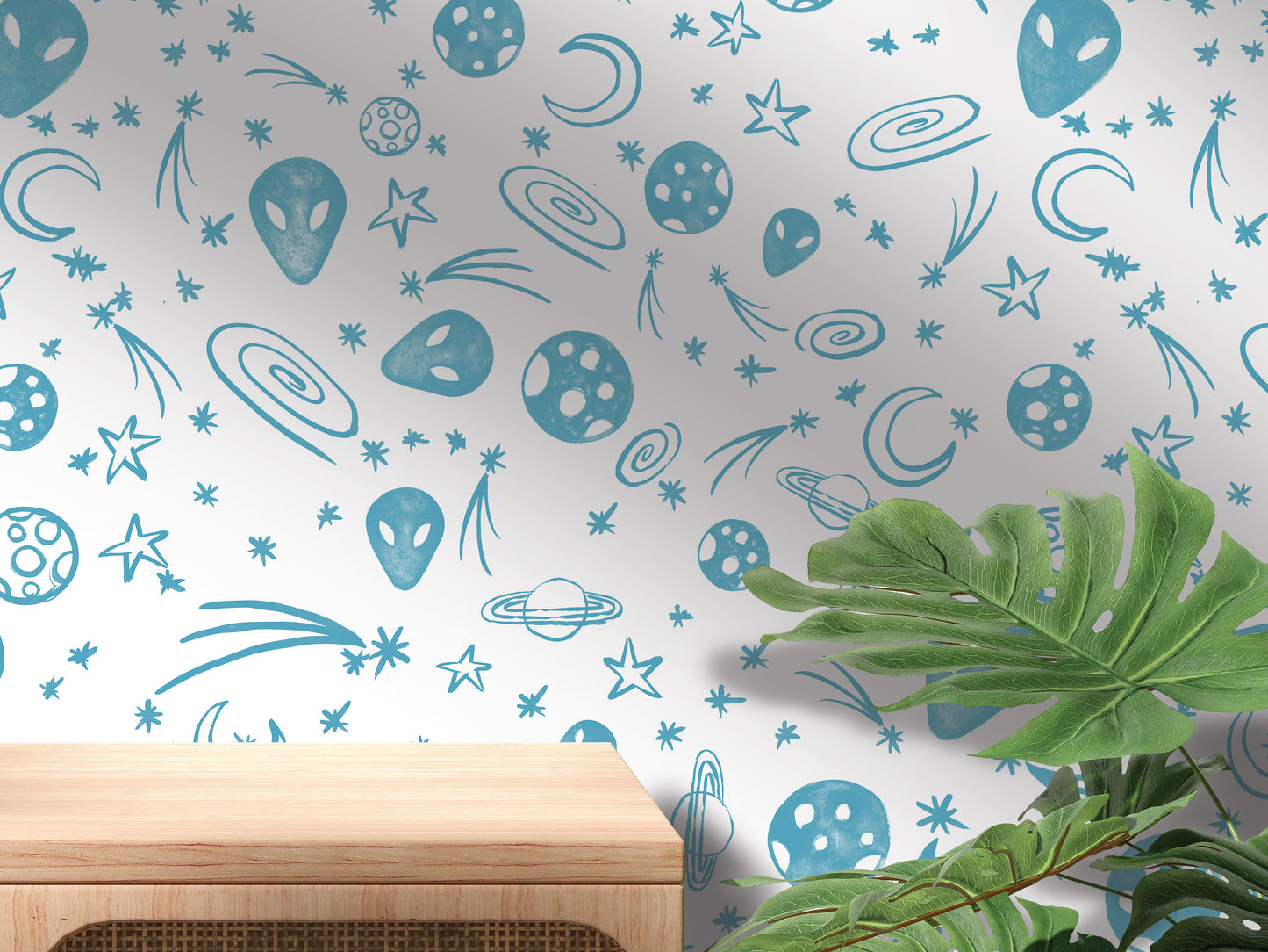 a wall with a pattern of blue and white celestial objects, including planets, stars, and comets, along with a wooden shelf and a plant in the foreground.