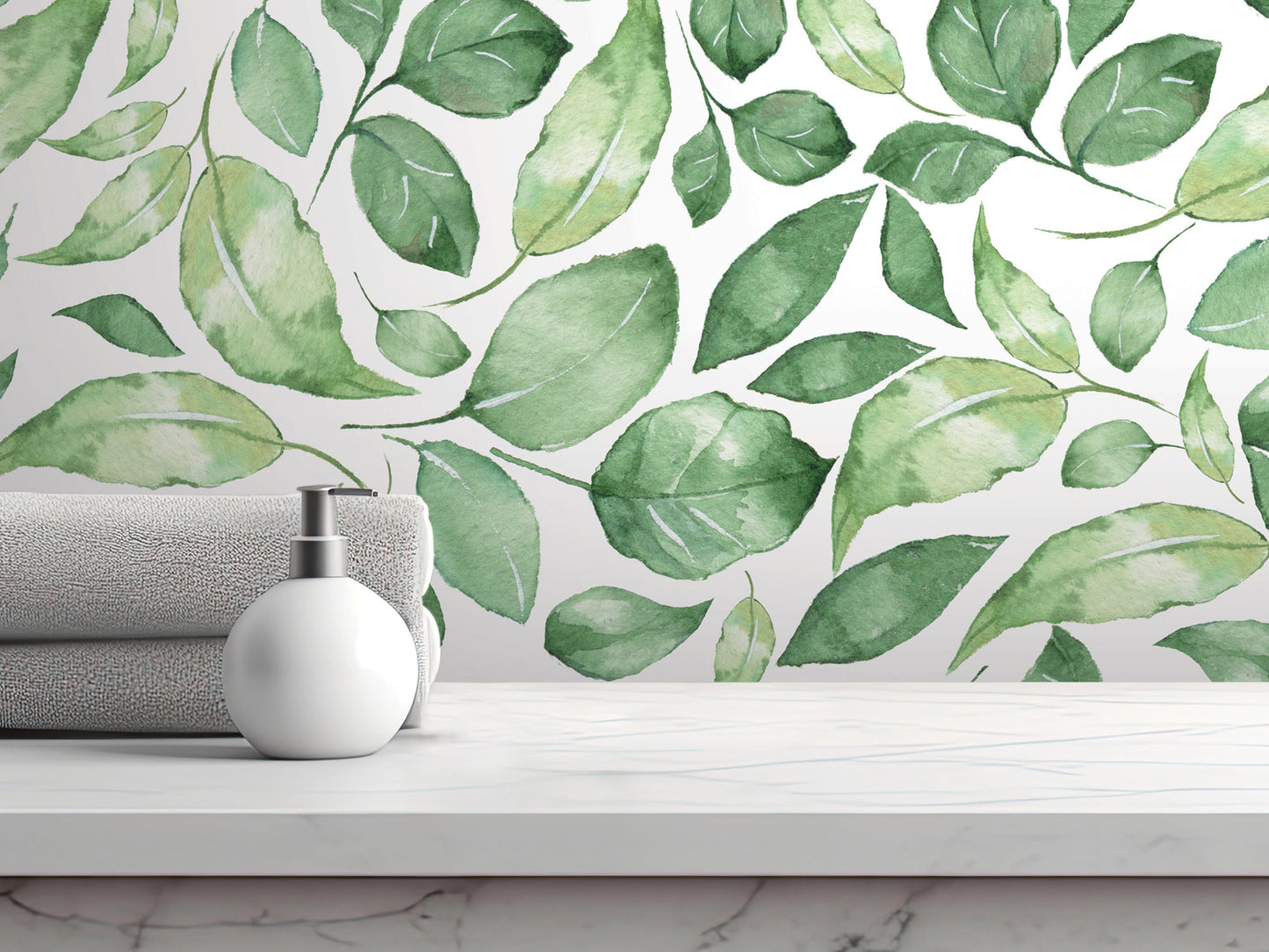 a white countertop with a white soap dispenser and a folded towel, set against a wall with a watercolor-style wallpaper pattern of green leaves.