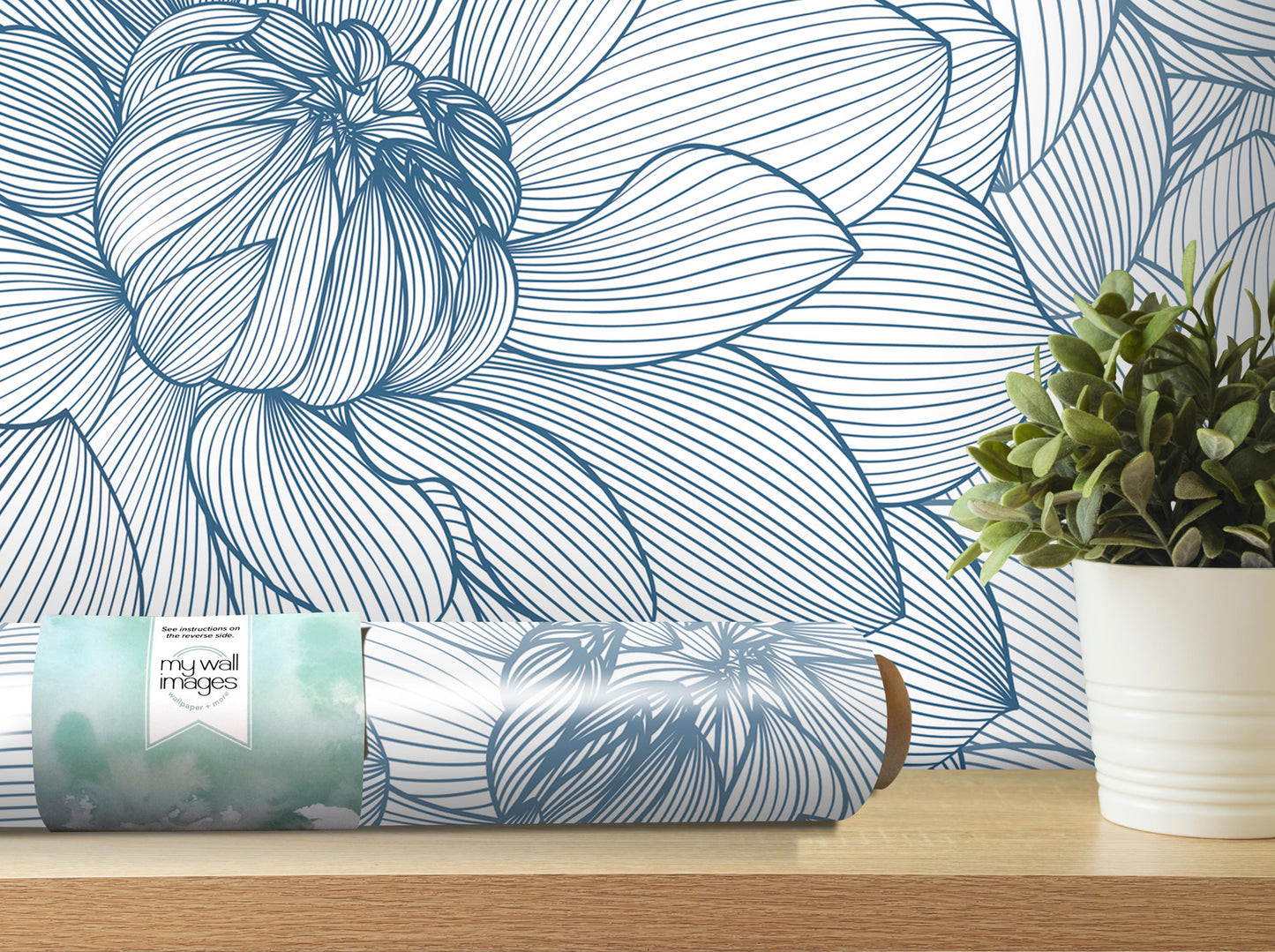 a wallpapered wall with a large blue and white floral pattern, a roll of wallpaper, and a potted plant on a shelf.