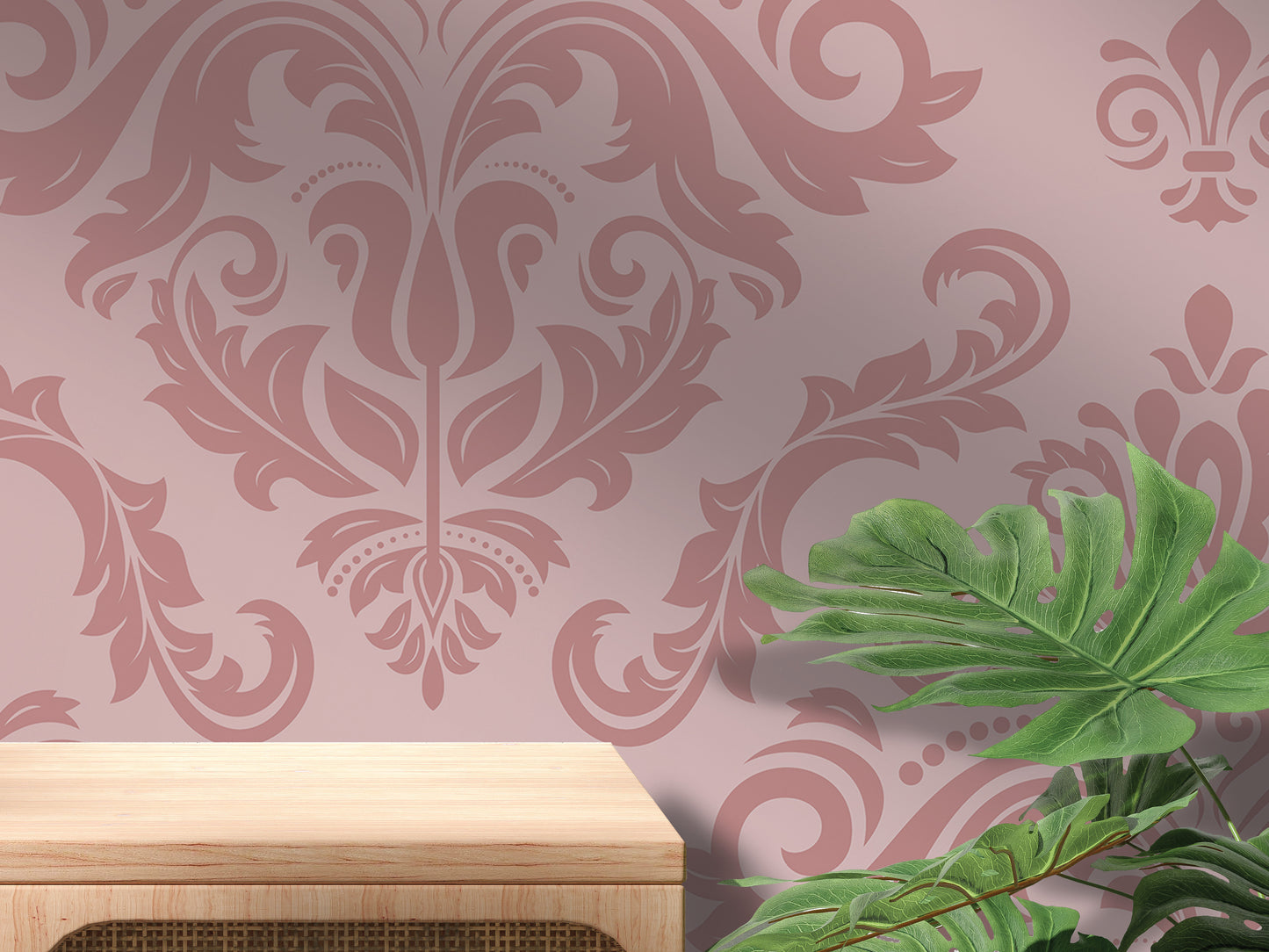 a pink wall with a floral pattern, a wooden table, and a large green leaf plant.