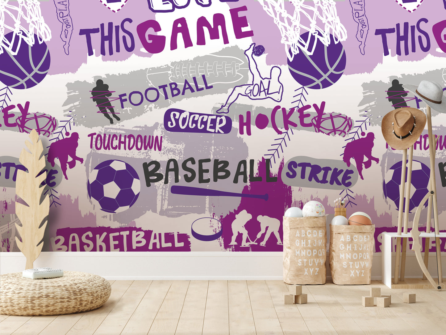 a wallpapered wall with various sports-related words and illustrations, including football, soccer, hockey, and basketball. There are also some wooden objects, such as a hat rack and a basket, placed in front of the wall.