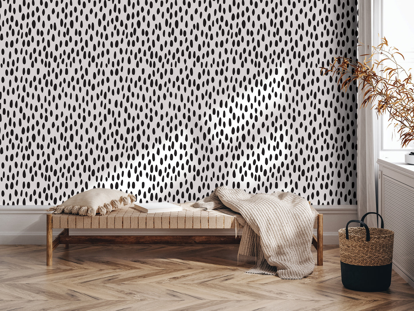 a modern and minimalist interior design with a black and white polka dot pattern on the wall behind a wooden bench. The bench is positioned on a hardwood floor, and there is a woven basket nearby. The overall aesthetic is clean and contemporary, with a focus on the use of bold patterns and textures.