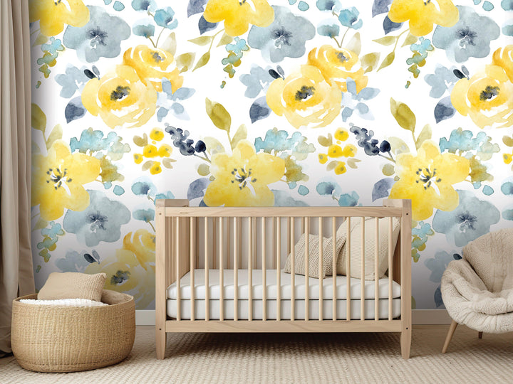 a nursery room with a wooden crib, a woven basket, and a beige chair. The walls are covered in a floral wallpaper with yellow and blue flowers.