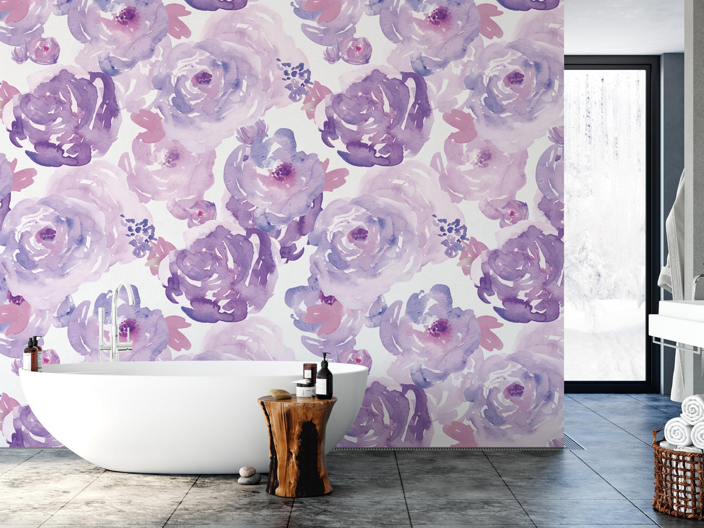 a bathroom with a large wall mural of purple and pink watercolor flowers. The wall is painted in a light purple color, and the flowers are depicted in a darker shade of purple. The bathroom has a white freestanding bathtub, and there is a wooden stool in front of it. The room also includes a window and a door, providing natural light and access to the space.
