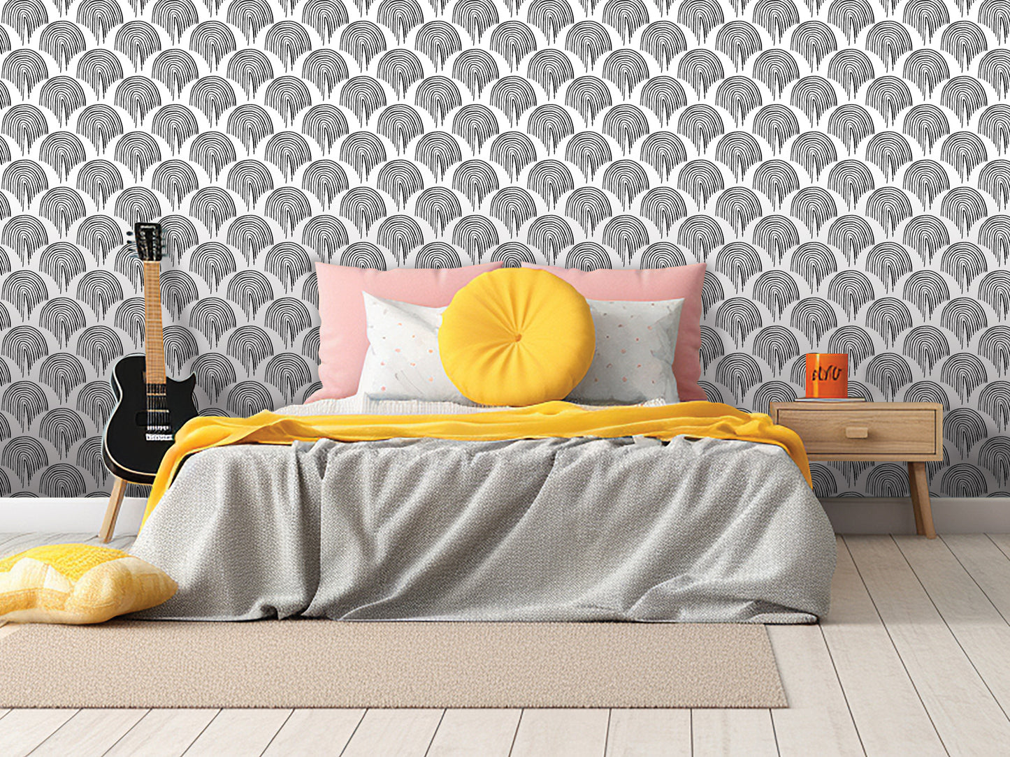 a modern bedroom with a gray bed, yellow throw pillow, and a black guitar. The walls are covered in a repeating pattern of black and white circles, creating a bold and stylish backdrop. The room also includes a wooden nightstand and a rug, contributing to the overall contemporary design.