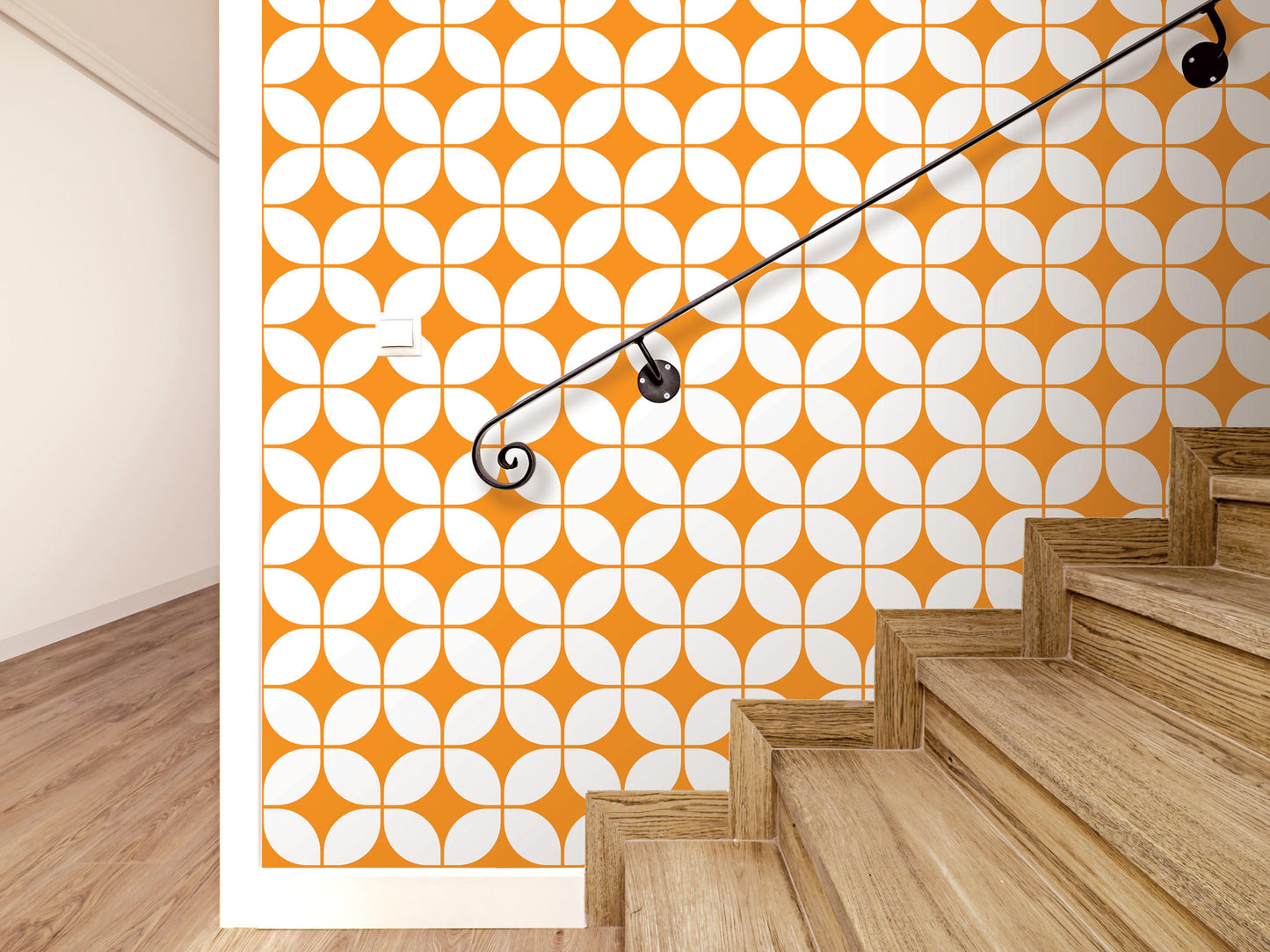 a staircase with wooden steps and a black metal handrail, set against a wall with a repeating pattern of orange and white circles.