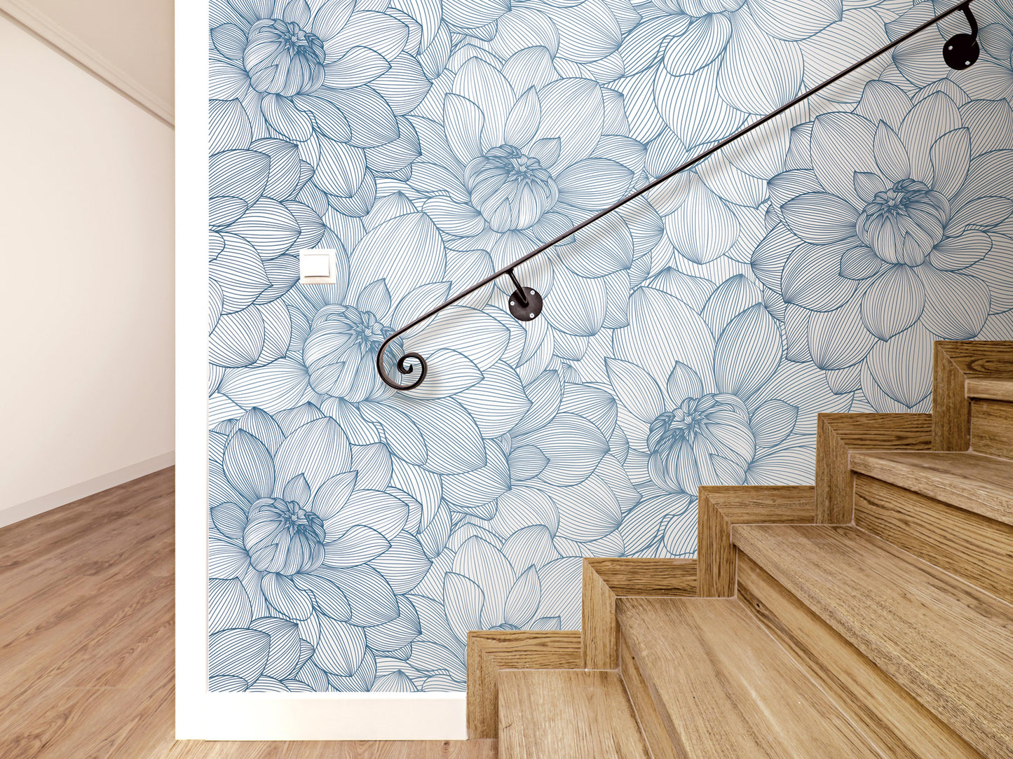 a wooden staircase with a blue and white floral patterned wall behind it, and a black metal handrail.
