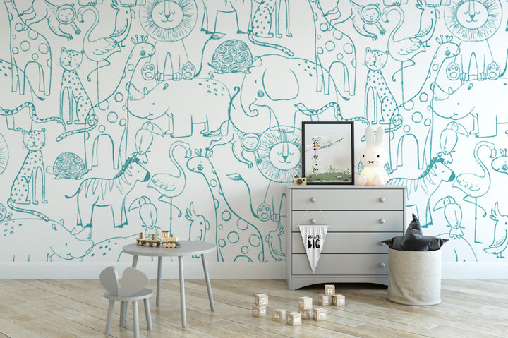 a child's bedroom with a white dresser, a small table with a toy car, and a basket filled with toys. The walls are decorated with a whimsical wallpaper of various animals and cartoon characters, creating a playful and imaginative atmosphere.