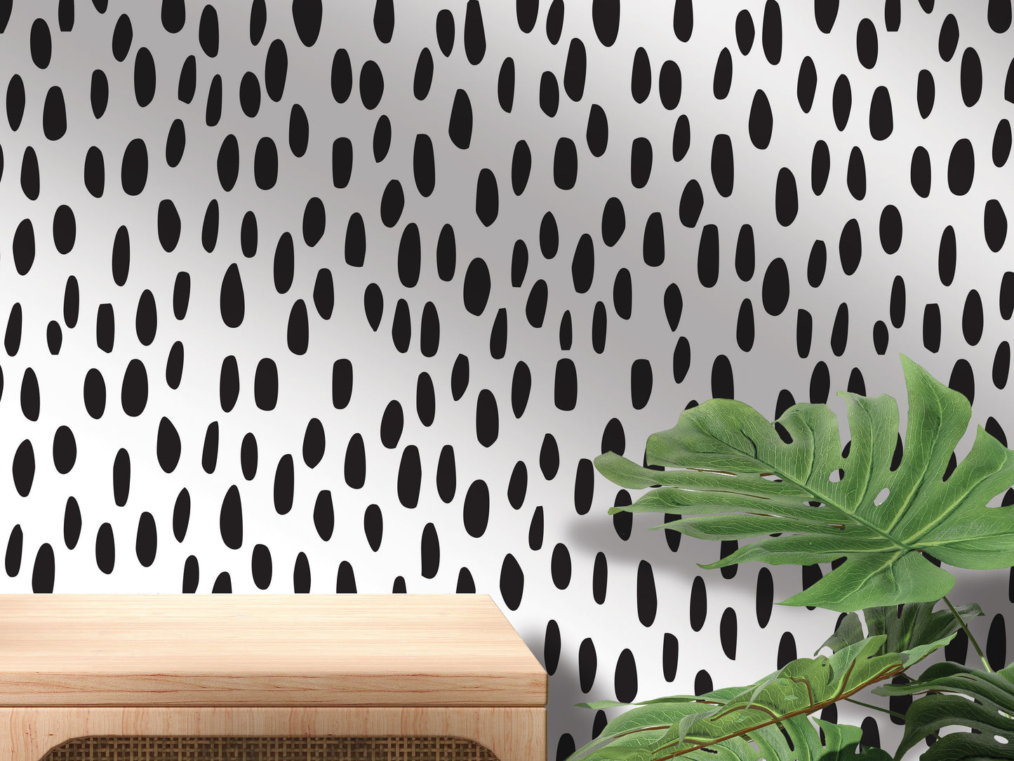 a wooden table with a plant on top of it, set against a wall with a black and white polka dot pattern.