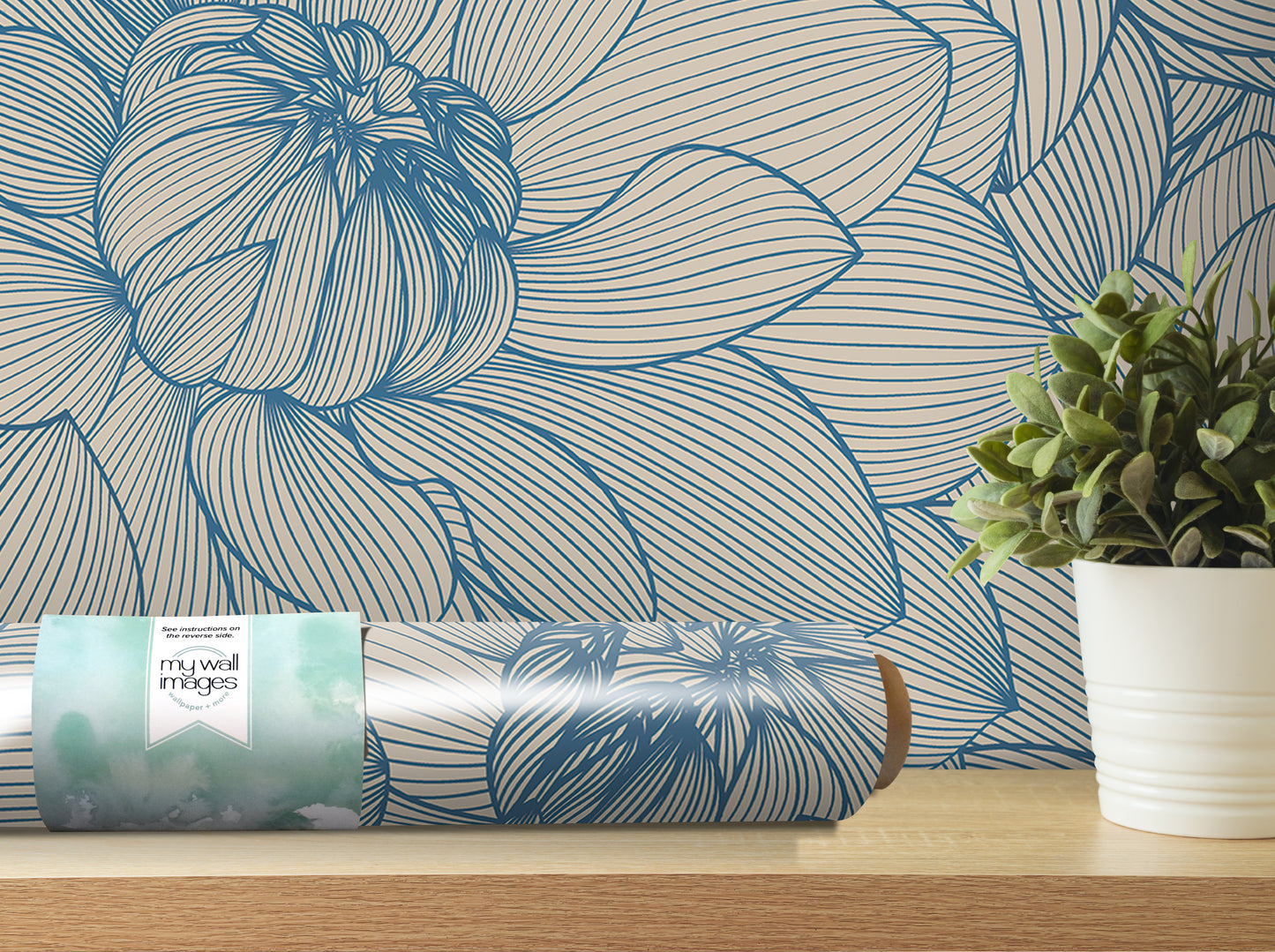 a blue and white floral wallpaper on the wall, with a potted plant and a roll of wallpaper paper on a shelf in the foreground.