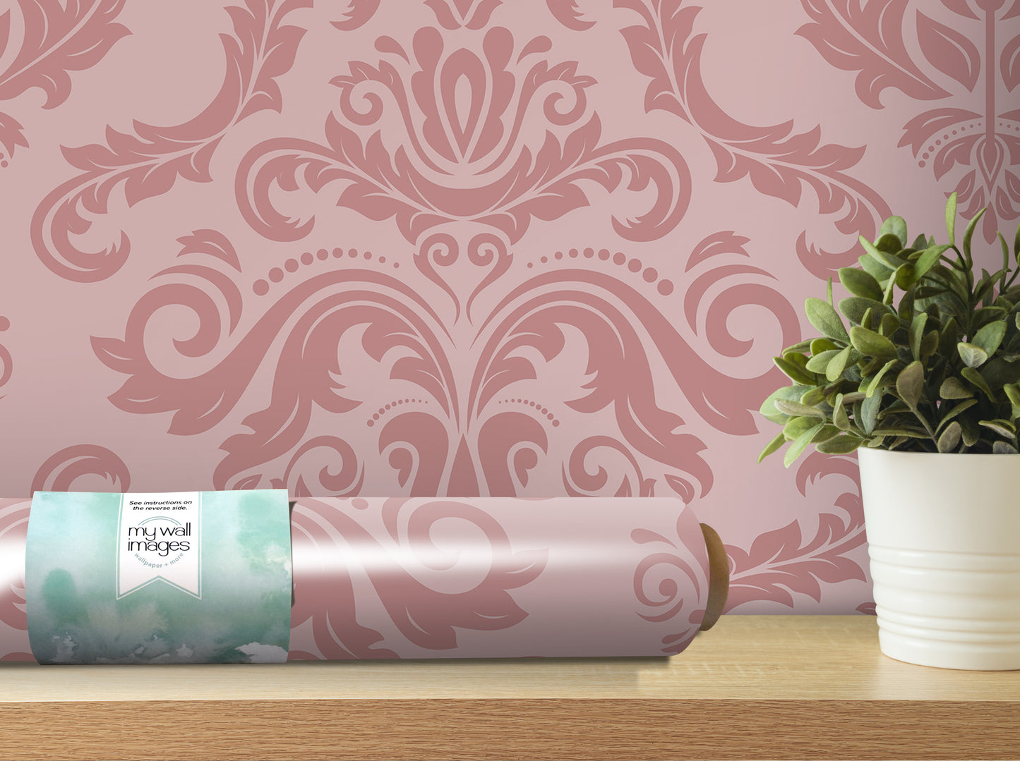 a pink damask wallpaper with a decorative floral pattern, a roll of wallpaper, and a potted plant on a wooden shelf.