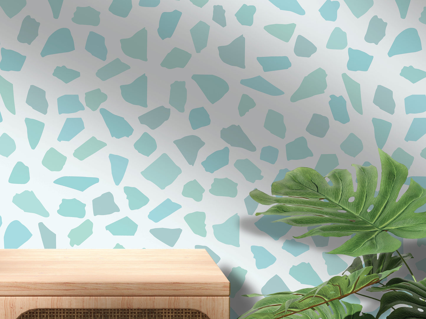 a wooden table with a plant on top of it, set against a wall with a pattern of small blue and green shapes.