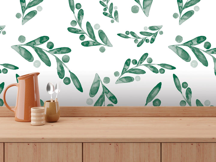 a wooden table topped with a vase filled with green leaves