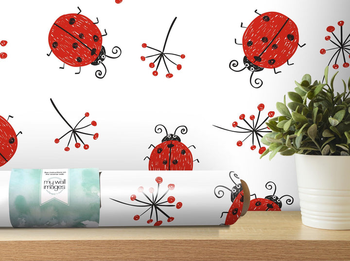 a plant in a white vase next to a white wall with red ladybugs