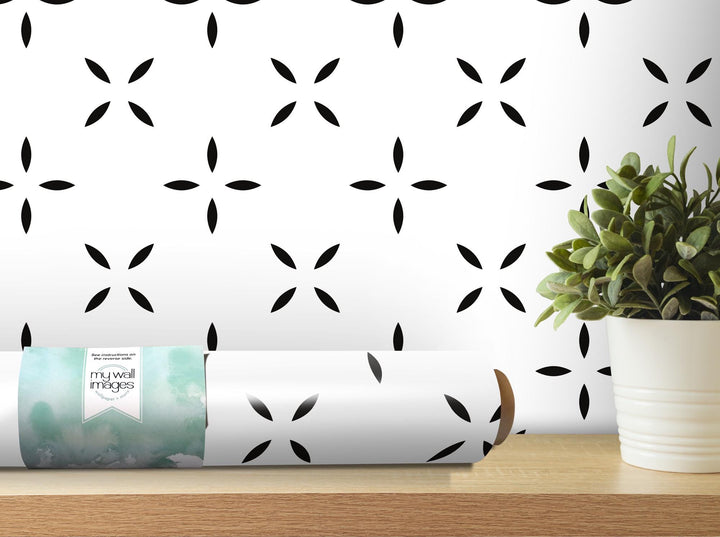 a plant is sitting on a table next to a roll of paper