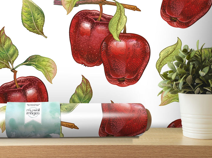 a painting of apples on a wall next to a potted plant