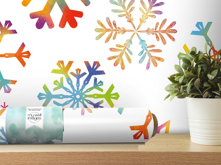 a white vase filled with a plant next to a snowflake wall decal