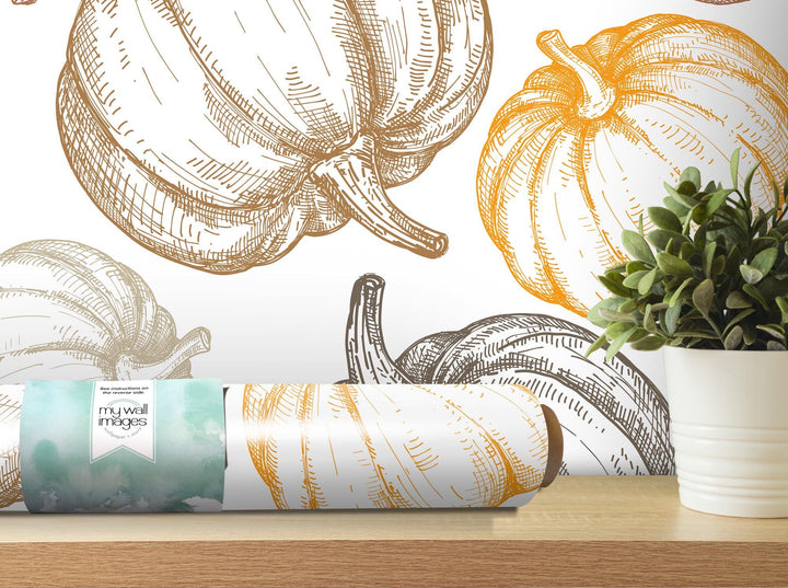 a painting of pumpkins on a wall next to a potted plant