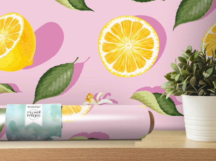 a pink wall with oranges and leaves on it