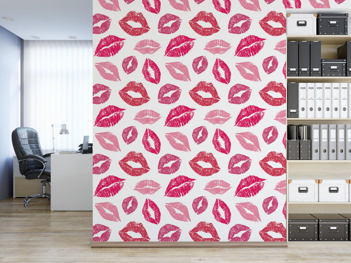 a room with a bookcase and a wall with pink lipstick prints