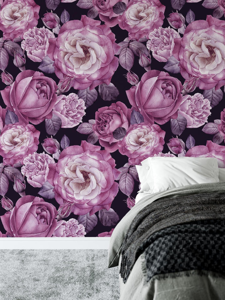 a bed sitting next to a wall covered in pink flowers