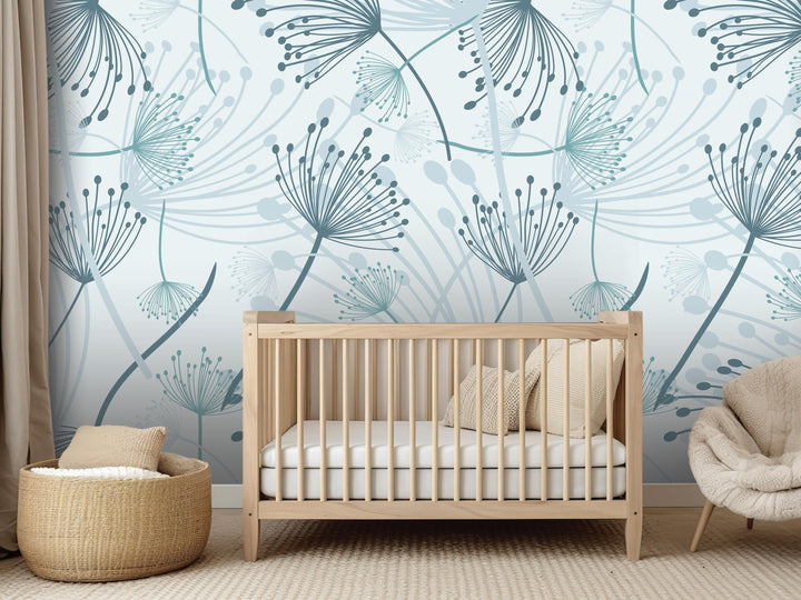 a nursery room with a wooden crib, a woven basket, and a plush chair. The walls are decorated with a pattern of blue and green dandelion-like flowers, creating a serene and calming atmosphere.