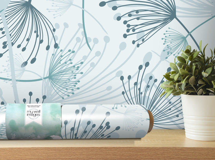 a wallpapered wall with a decorative pattern of blue and green lines and shapes, and a potted plant placed on a shelf next to the wall.