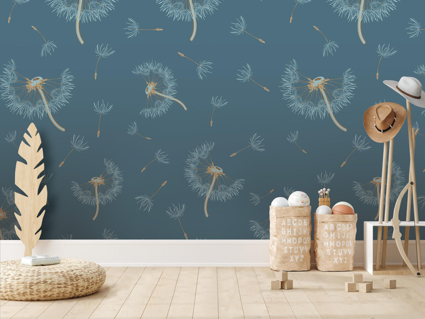 a room with a blue wall adorned with a pattern of dandelions. In the foreground, there are two baskets filled with alphabet blocks, and a wooden stool. A hat is also present in the scene.