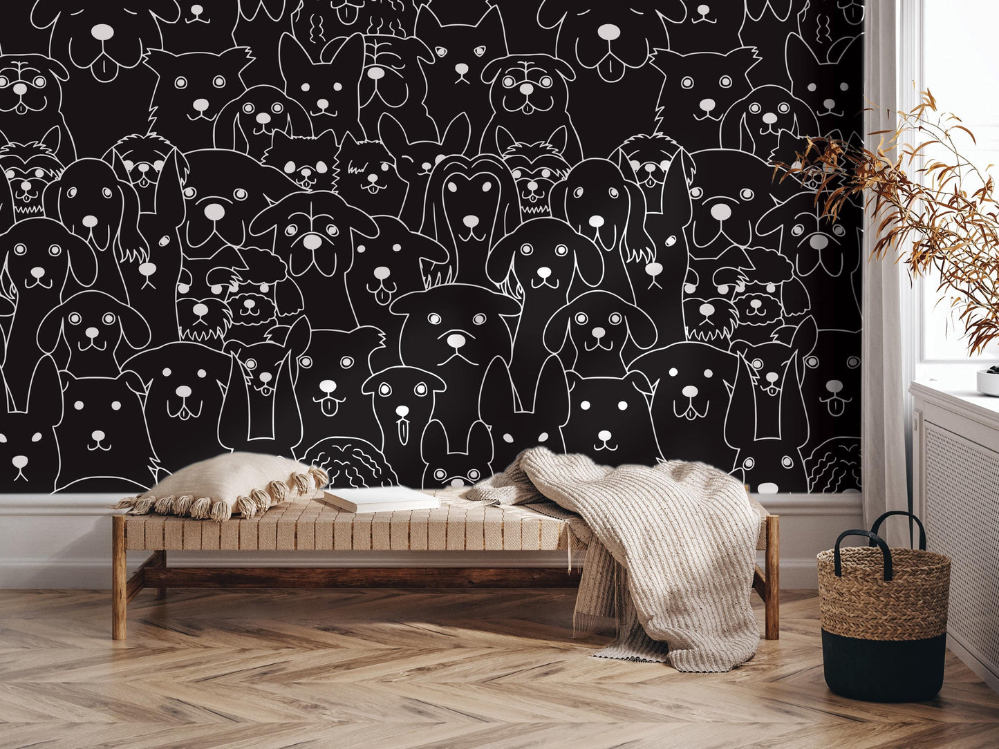 a black and white wall mural depicting a large group of stylized dogs. In the foreground, there is a wooden bench with a blanket draped over it, and a woven basket is placed next to it.